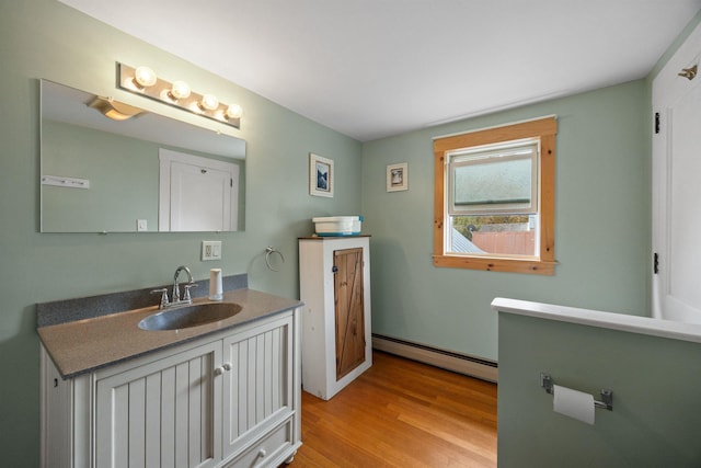 bathroom featuring a baseboard radiator, wood finished floors, and vanity