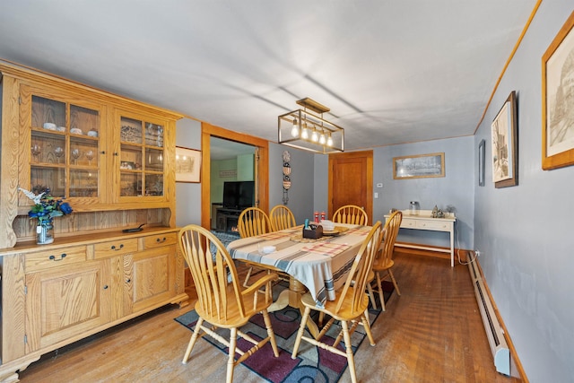 dining room with baseboards, a baseboard radiator, and light wood-style floors