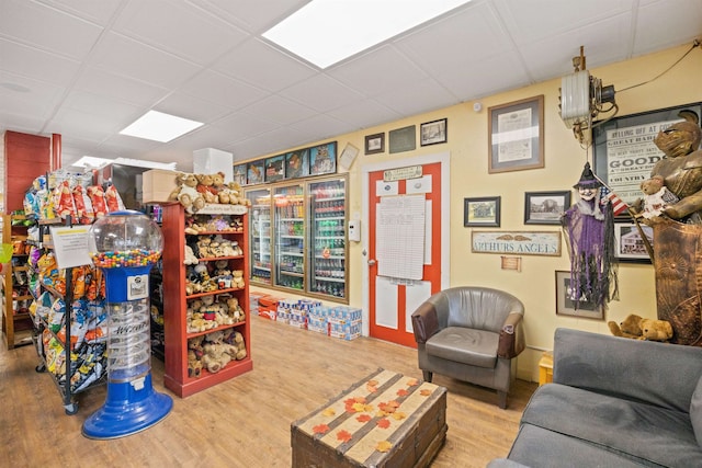 interior space with a drop ceiling and wood finished floors