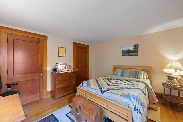 bedroom with light wood-style floors and baseboards