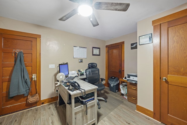 office space with a ceiling fan, light wood-type flooring, and baseboards