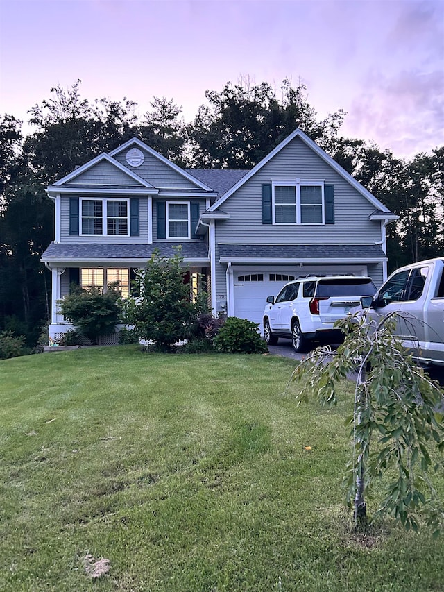 view of front of home featuring a garage and a yard