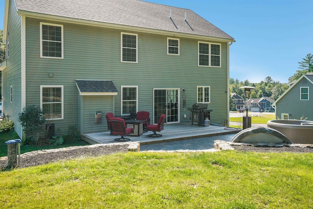 rear view of house featuring a yard and a wooden deck