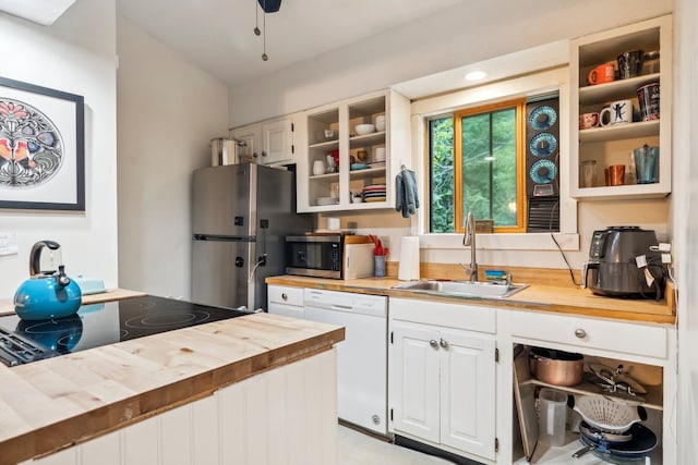 kitchen with sink, white cabinetry, butcher block countertops, and stainless steel appliances