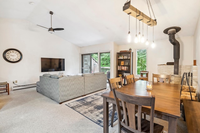 dining space featuring ceiling fan, carpet, baseboard heating, and a wood stove