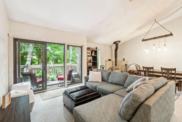 carpeted living room with a wood stove and lofted ceiling