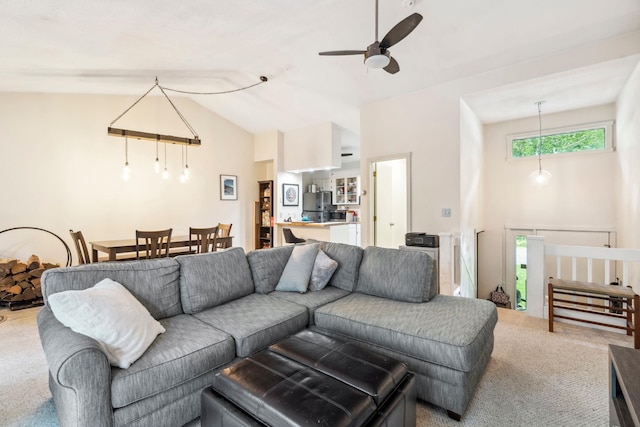 carpeted living room with ceiling fan and high vaulted ceiling