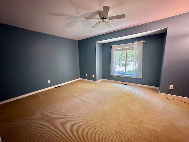 carpeted empty room featuring ceiling fan