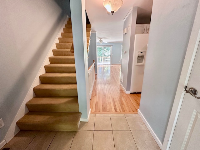 staircase featuring hardwood / wood-style floors and ceiling fan