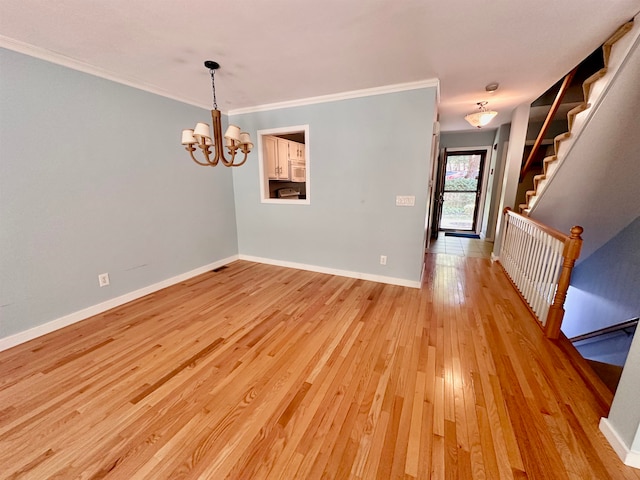 interior space with crown molding, an inviting chandelier, and light hardwood / wood-style floors