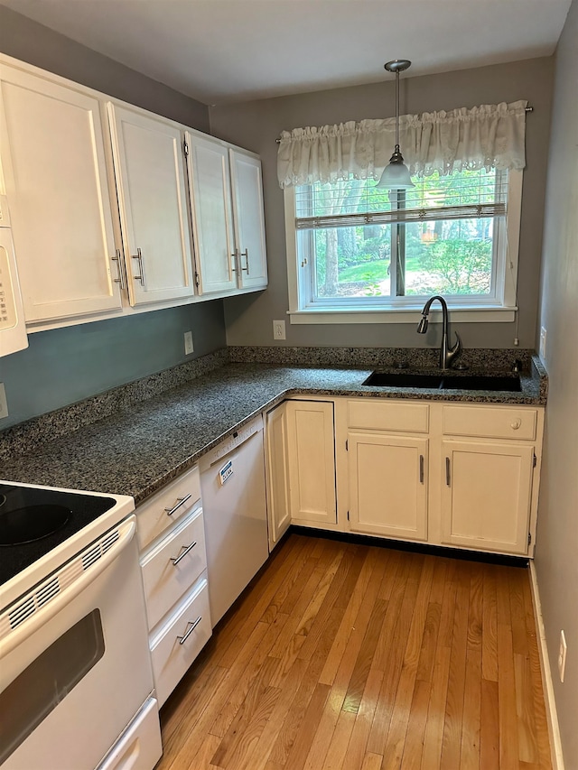 kitchen with light hardwood / wood-style floors, sink, white appliances, and white cabinetry