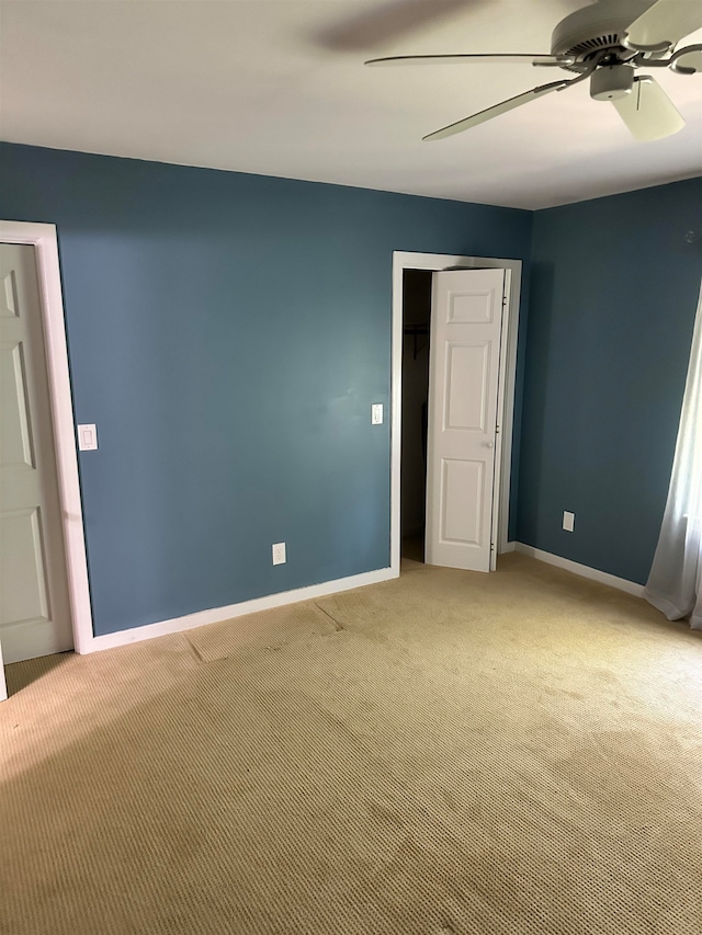 carpeted spare room featuring ceiling fan