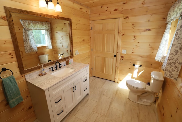 bathroom with tile patterned floors, wooden walls, vanity, and toilet