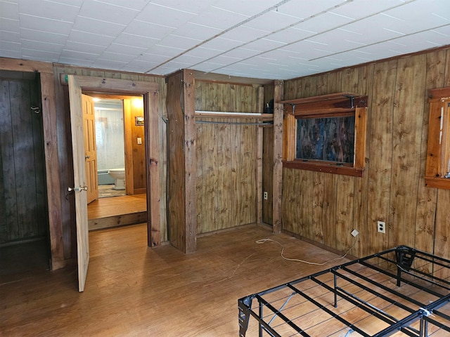 bedroom featuring hardwood / wood-style flooring and wooden walls