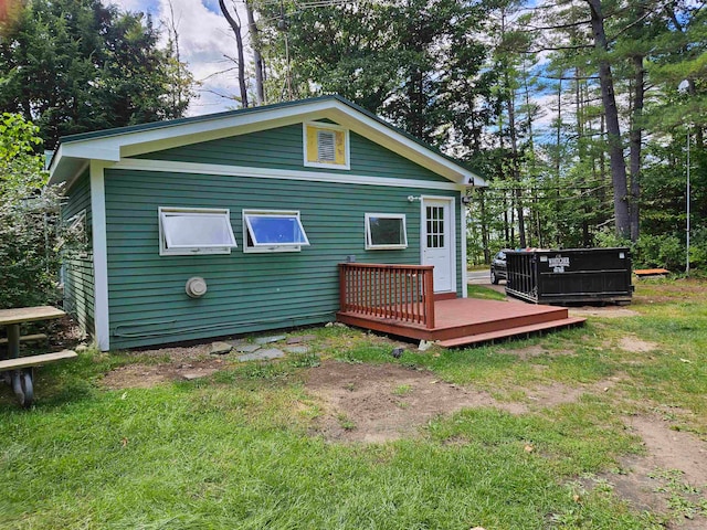 rear view of house featuring a lawn and a wooden deck