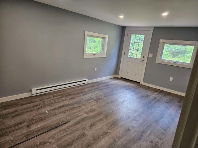 foyer entrance featuring hardwood / wood-style floors, lofted ceiling, and a baseboard heating unit