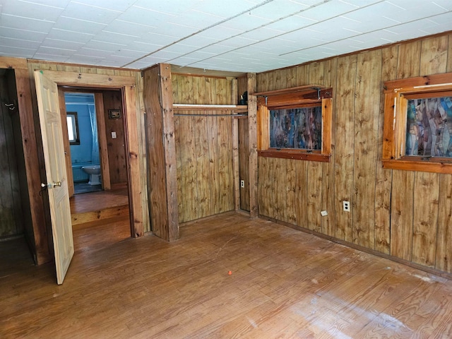 empty room with wood-type flooring and wooden walls