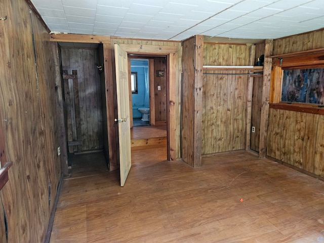 hall with light hardwood / wood-style flooring and wooden walls