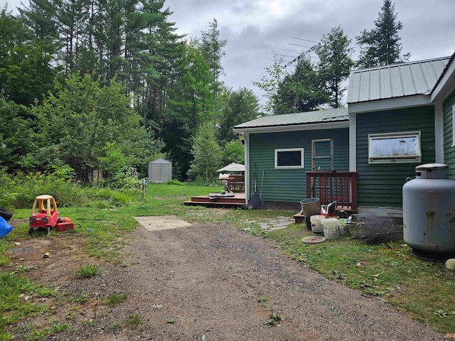 view of yard featuring a storage shed and a wooden deck