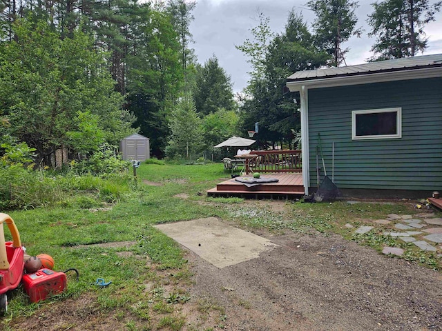 view of yard with a deck and a storage shed