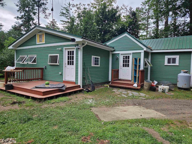 rear view of property with a deck and a lawn