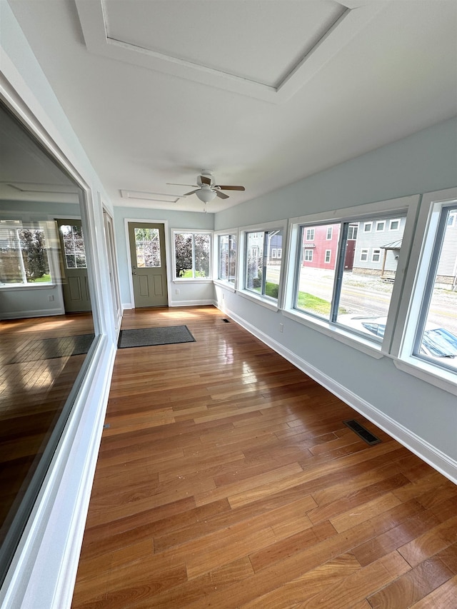 unfurnished sunroom with ceiling fan