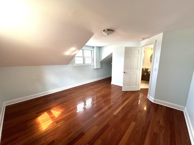 additional living space with dark wood-type flooring and lofted ceiling