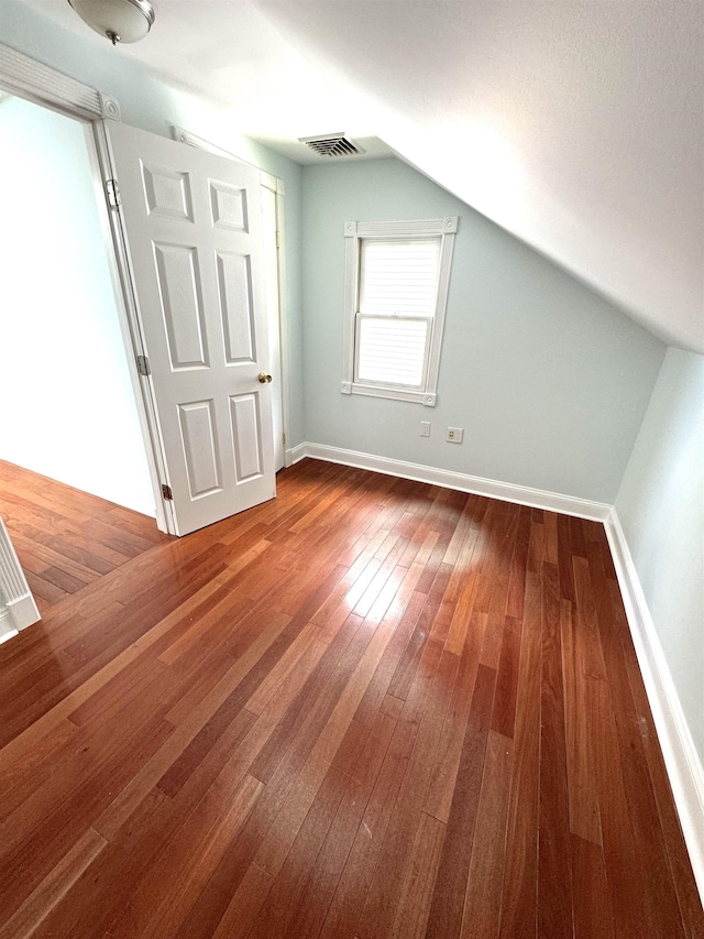 bonus room with vaulted ceiling and wood-type flooring