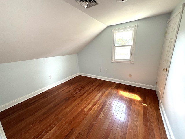 additional living space with vaulted ceiling and wood-type flooring