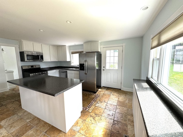 kitchen featuring sink, stainless steel appliances, light tile patterned flooring, and a breakfast bar area