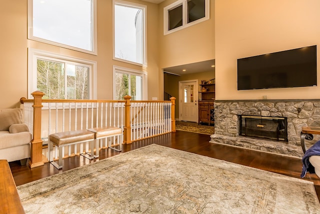 living room with a high ceiling, dark hardwood / wood-style flooring, and a fireplace