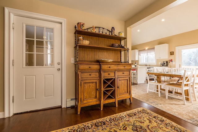 bar featuring white cabinets, dark hardwood / wood-style floors, dishwasher, and a baseboard radiator