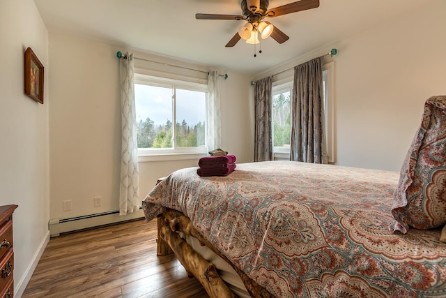 bedroom featuring ceiling fan, baseboard heating, and hardwood / wood-style floors