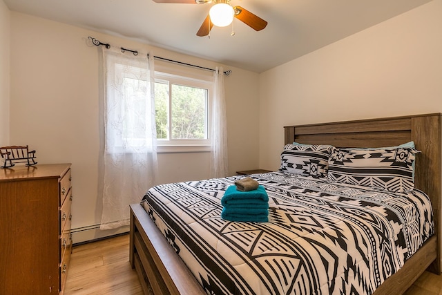 bedroom with ceiling fan, light hardwood / wood-style flooring, and baseboard heating