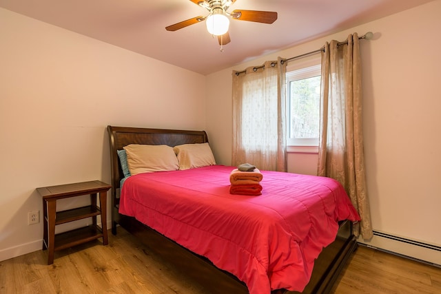 bedroom featuring light hardwood / wood-style floors, ceiling fan, and baseboard heating