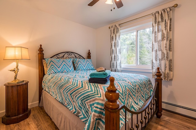 bedroom with ceiling fan, hardwood / wood-style floors, and a baseboard radiator