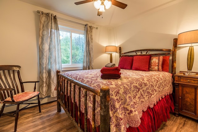 bedroom featuring ceiling fan, baseboard heating, and hardwood / wood-style flooring