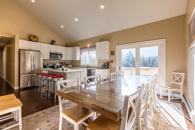 dining space with high vaulted ceiling, sink, and dark hardwood / wood-style flooring