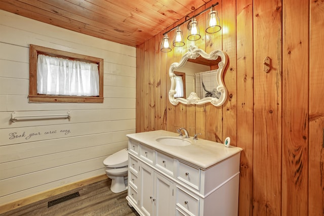 bathroom with wood walls, hardwood / wood-style floors, vanity, wood ceiling, and toilet