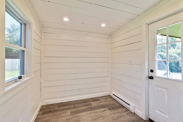 doorway featuring dark hardwood / wood-style floors, a baseboard heating unit, and wooden walls