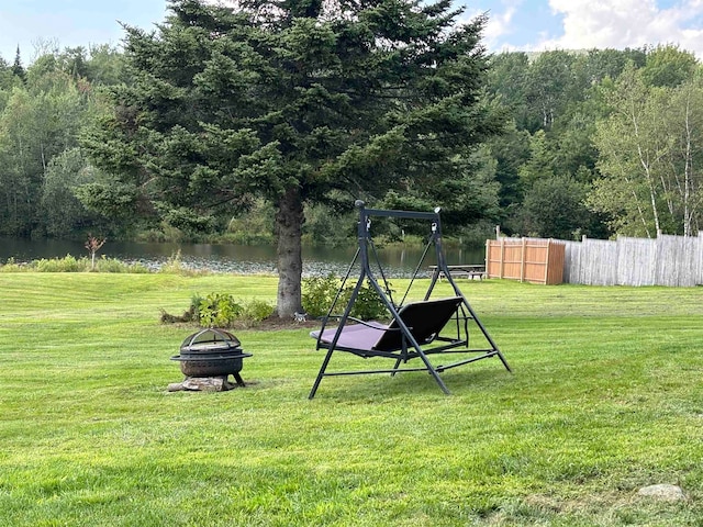 view of yard with an outdoor fire pit and a water view