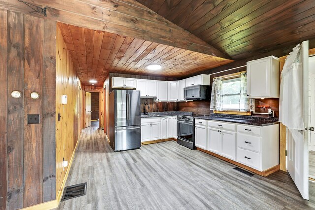 kitchen featuring stainless steel refrigerator, electric stove, light wood-type flooring, wooden walls, and wooden ceiling