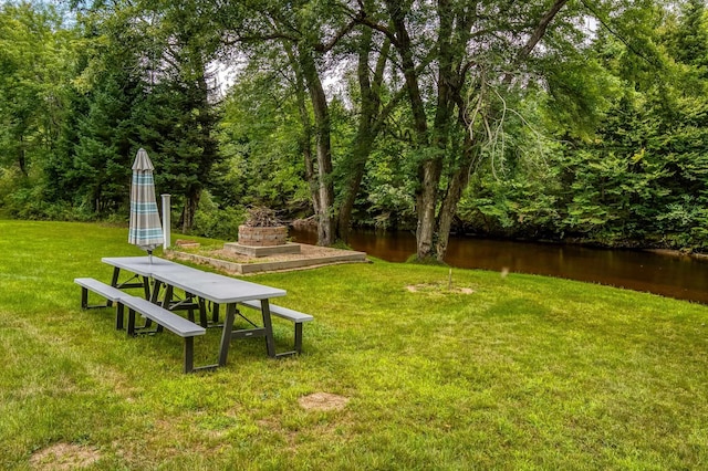 view of yard with a water view and a wooded view