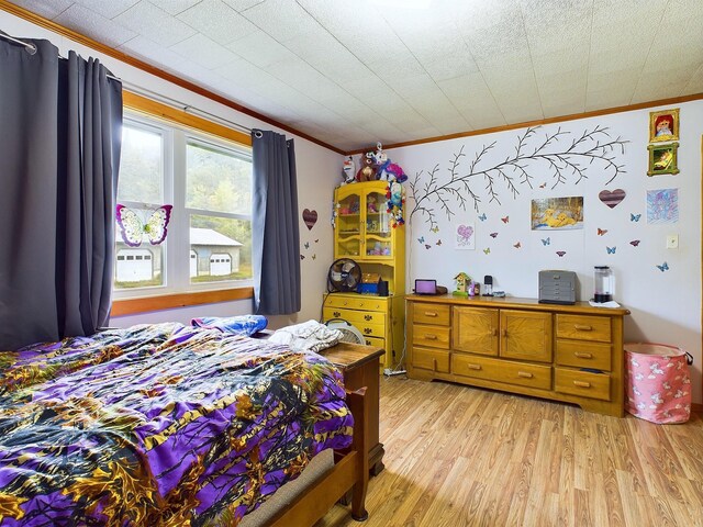 bedroom featuring light hardwood / wood-style flooring and ornamental molding