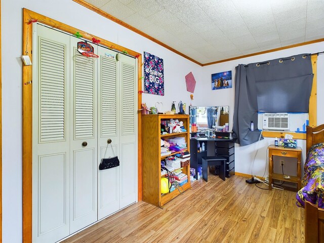 game room with light wood-type flooring, cooling unit, and ornamental molding