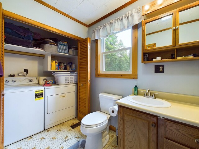 bathroom featuring separate washer and dryer, tile patterned floors, vanity, crown molding, and toilet