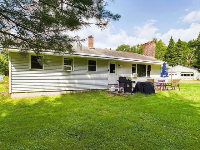 back of property with a yard and a garage