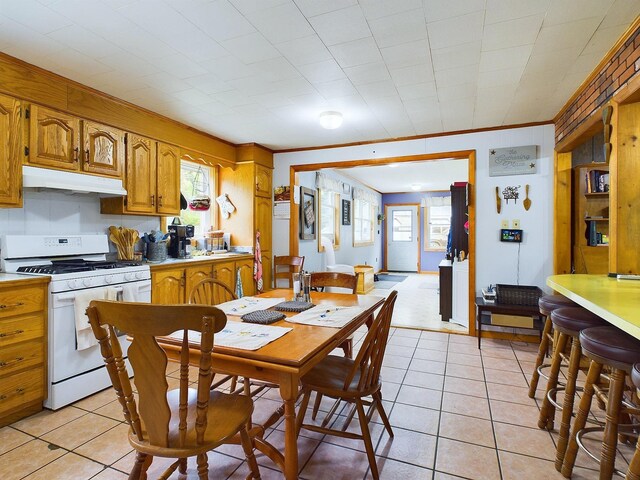 kitchen featuring a healthy amount of sunlight, light tile patterned floors, and gas range gas stove