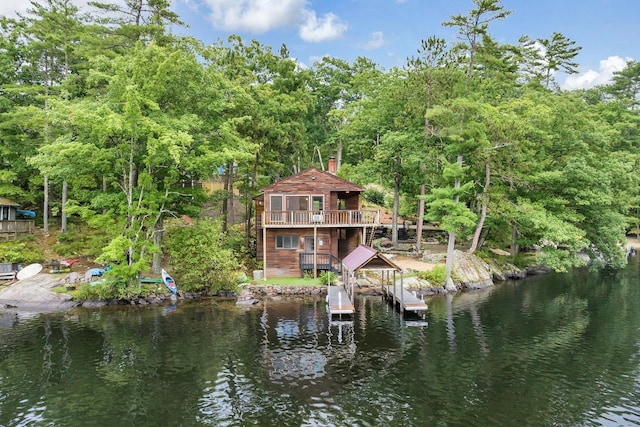 rear view of property with a water view and a chimney