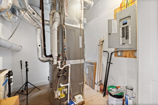 utility room featuring heating unit and electric panel